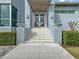 Modern home entrance with double doors, stone steps, and manicured hedges at 705 Jungle Queen Way, Longboat Key, FL 34228