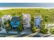 Beachfront property showcasing three modern homes with ocean views at 648 Beach Rd, Sarasota, FL 34242