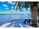 Scenic waterfront view with a bench under a palm tree at 4540 Gulf Of Mexico Dr # Ph1, Longboat Key, FL 34228