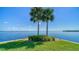 Stunning waterfront view with palm trees and a bench at 4540 Gulf Of Mexico Dr # Ph1, Longboat Key, FL 34228