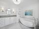 Elegant bathroom with freestanding soaking tub, marble flooring, and modern vanity at 1400 Quail Dr, Sarasota, FL 34231