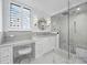 Spa-like bathroom with walk-in shower, marble flooring, and vanity at 1400 Quail Dr, Sarasota, FL 34231