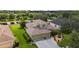 An aerial view of a home with well-maintained landscaping, a pond view, and a three-car garage at 432 Snapdragon Loop, Bradenton, FL 34212