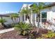 Landscaped front yard with palm trees and well-manicured shrubs at 10622 Cheval Pl, Lakewood Ranch, FL 34202