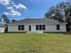 Back exterior view of the property with well-kept lawn and multiple windows at 2968 Yacolt Ave, North Port, FL 34286