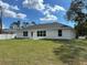 Spacious backyard with green grass and exterior view of a house at 2968 Yacolt Ave, North Port, FL 34286