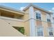 Tan building with white trim, balconies, and stairs, offering a charming exterior at 1050 Villagio Cir # 206, Sarasota, FL 34237