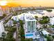 Aerial view of modern condo building with pool and marina views at sunset at 111 Golden Gate Pt # 201, Sarasota, FL 34236