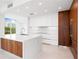 Modern kitchen with white and wood cabinets at 111 Golden Gate Pt # 201, Sarasota, FL 34236