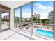 Sunlit living room with stunning pool and city views at 111 Golden Gate Pt # 201, Sarasota, FL 34236