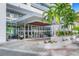 Modern building entrance with palm trees and a paved walkway at 1155 N Gulfstream Ave # 208, Sarasota, FL 34236