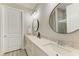 Double vanity bathroom with modern fixtures and a large, round mirror at 17006 Hampton Falls Ter, Lakewood Ranch, FL 34202