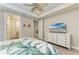 Main bedroom with a TV and white dresser at 17006 Hampton Falls Ter, Lakewood Ranch, FL 34202