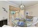 Dining room with glass table, four chairs, and a view to the kitchen at 17006 Hampton Falls Ter, Lakewood Ranch, FL 34202