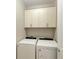 Convenient laundry room with washer, dryer, and overhead cabinets at 17006 Hampton Falls Ter, Lakewood Ranch, FL 34202