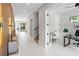 Light-filled entryway with wood wall accents and views into an office and staircase at 3464 Camino Real, Sarasota, FL 34239