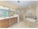 Bathroom featuring a double vanity, glass shower, soaking tub and neutral color scheme at 6708 Grand Estuary Trl # 104, Bradenton, FL 34212