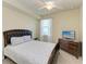 Bedroom with a wood-framed bed, ceiling fan, dresser, and plenty of natural light at 6708 Grand Estuary Trl # 104, Bradenton, FL 34212