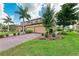 Beautiful two-story home showcasing a three-car garage, manicured lawn, and vibrant landscaping at 6708 Grand Estuary Trl # 104, Bradenton, FL 34212