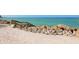 Sandy beach with wooden stairs and rocks at 7665 Sanderling Rd, Sarasota, FL 34242