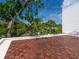 Spacious deck with wood tile flooring and lush tropical landscaping at 7665 Sanderling Rd, Sarasota, FL 34242