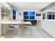 Modern dining area with white table and grey chairs near kitchen at 7665 Sanderling Rd, Sarasota, FL 34242