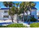 White house with solar panels, palm trees, and a spacious backyard at 7665 Sanderling Rd, Sarasota, FL 34242