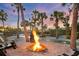 Fire pit surrounded by palm trees at sunset at 7665 Sanderling Rd, Sarasota, FL 34242
