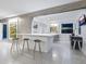 Open kitchen with white cabinets, terrazzo flooring, and breakfast bar with seating at 7665 Sanderling Rd, Sarasota, FL 34242