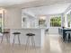 Open kitchen with white cabinets, terrazzo flooring, and breakfast bar with seating at 7665 Sanderling Rd, Sarasota, FL 34242