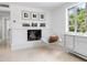 Bright living room with fireplace, hardwood floors and large window at 7665 Sanderling Rd, Sarasota, FL 34242