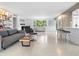 Open living area with gray couch, armchairs, and a large window at 7665 Sanderling Rd, Sarasota, FL 34242