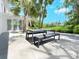 Outdoor patio with table, bench, and lush tropical landscaping at 7665 Sanderling Rd, Sarasota, FL 34242