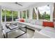 Sunroom boasts ample natural light, comfy sectional sofa, and tranquil water views at 7665 Sanderling Rd, Sarasota, FL 34242