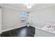 Well-lit bedroom with dark hardwood floors and a built-in shelving unit at 7889 Mainsail Ln, Sarasota, FL 34240