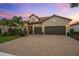 Two-story house with three car garage, paver driveway, and lush landscaping at 7889 Mainsail Ln, Sarasota, FL 34240