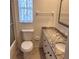 Bathroom with granite countertop, toilet and sink at 3638 Winderwood Dr, Sarasota, FL 34232