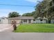 Ranch style home with a green exterior, red front door, and well-manicured lawn at 5680 Blount Ave, Sarasota, FL 34231