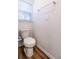 Small bathroom with toilet and wood-look flooring at 1702 Rada Ln, North Port, FL 34288