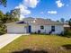 Front view of a recently built house showcasing a neutral exterior and landscaping at 1702 Rada Ln, North Port, FL 34288