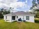 Rear view of a white house with covered patio and AC unit at 1702 Rada Ln, North Port, FL 34288