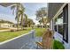 Relaxing front porch view of the neighborhood featuring mature landscaping, palm trees, and lush green lawns at 2806 67Th W St, Bradenton, FL 34209