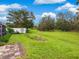 Spacious backyard with lush lawn and trees at 5050 Kestral Park S Way, Sarasota, FL 34231