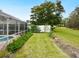 Landscaped backyard with lush greenery and spacious lawn at 5050 Kestral Park S Way, Sarasota, FL 34231