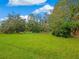 Large grassy backyard with mature trees at 5050 Kestral Park S Way, Sarasota, FL 34231