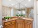 Corner vanity with granite countertop and large corner mirror at 5050 Kestral Park S Way, Sarasota, FL 34231