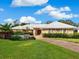 Landscaped yard, single-story home with a double-car garage and stone accents at 5050 Kestral Park S Way, Sarasota, FL 34231