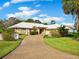 Single-story home with stone accents, mature landscaping, and a long driveway at 5050 Kestral Park S Way, Sarasota, FL 34231