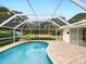 Relaxing kidney-shaped pool with screened enclosure and backyard view at 5050 Kestral Park S Way, Sarasota, FL 34231