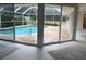 Stunning pool view from covered patio with sliding glass doors at 5050 Kestral Park S Way, Sarasota, FL 34231